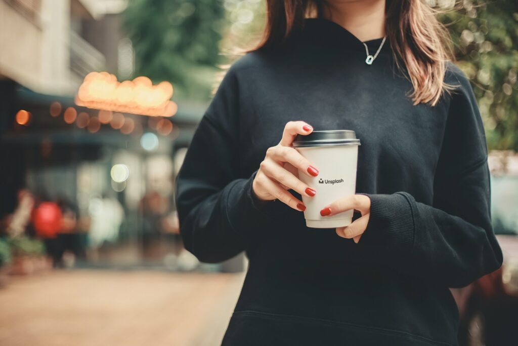 woman in black long sleeve shirt holding white ceramic mug